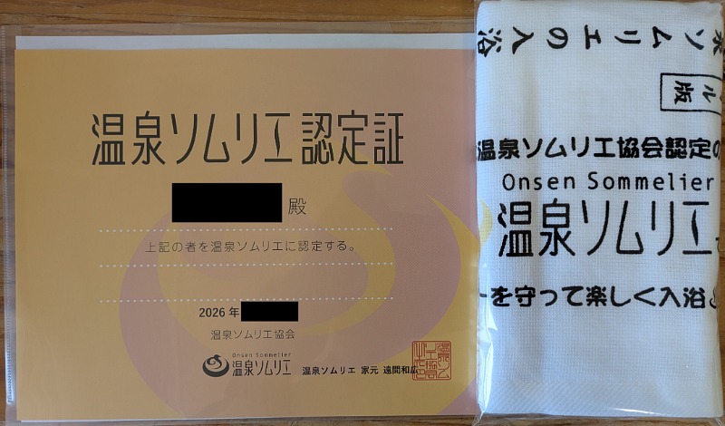 温泉ソムリエ認定証とタオルが並んでいる様子